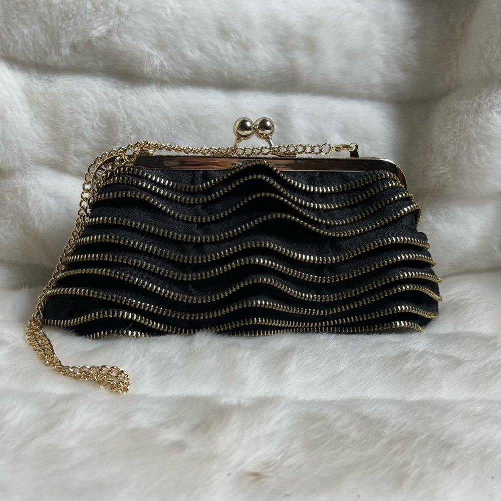 Susan Faris Satin black clutch with gold tone zipper tiered motif and frame.